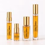 Four gold-capped Ambre Sultan decants with transparent labels and golden-orange perfume