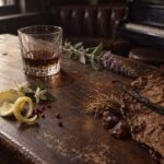 Rum, tobacco leaf, vanilla, lemon, pink pepper, orange blossoms, clary sage, vetiver roots and resin on a worn wooden table in a jazz lounge